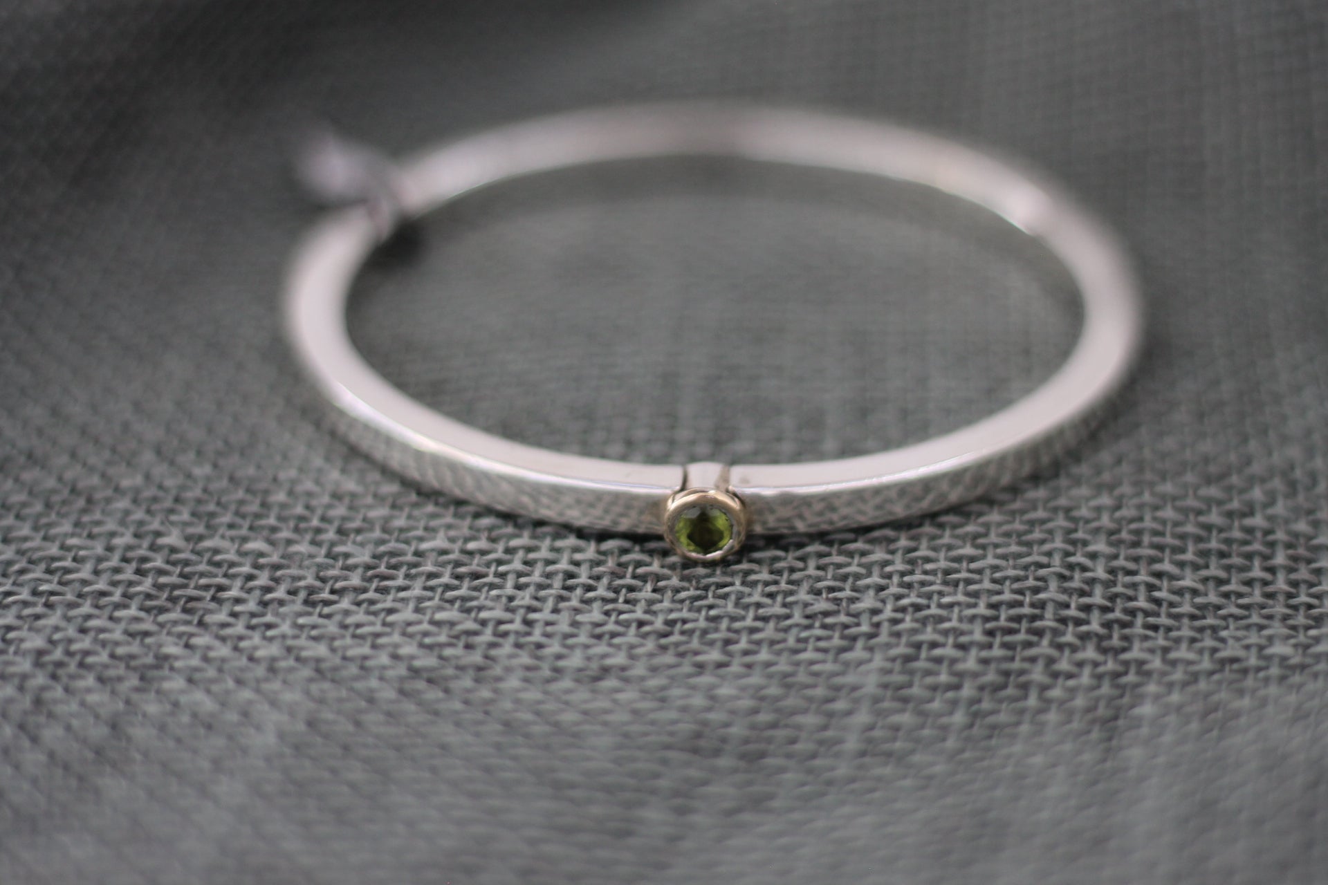 Silver and peridot bangle by Angus Thomson
